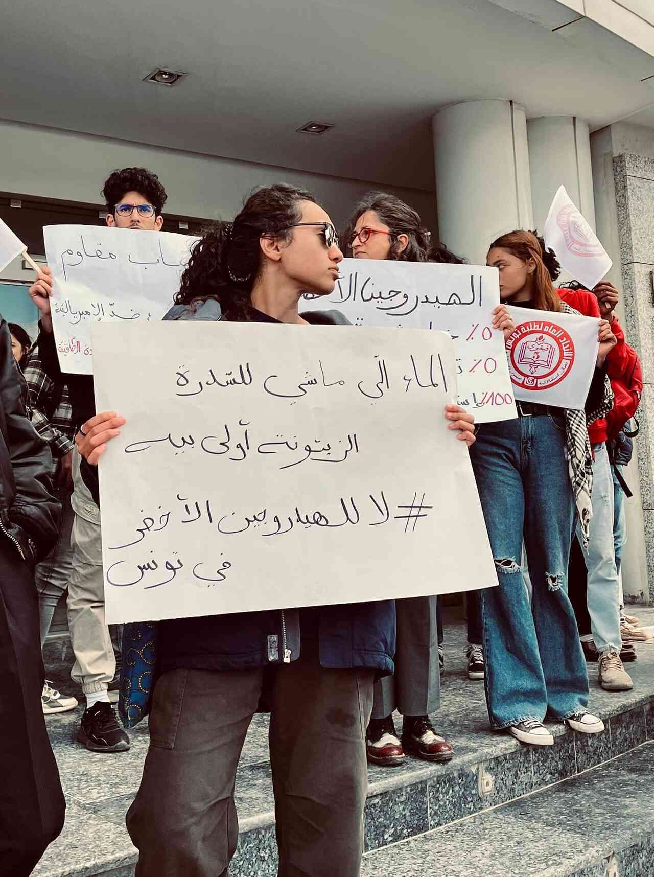 Protesters hold up signs about water scarcity linked to green hydrogen projects and warning against neo imperialism in Tunisia